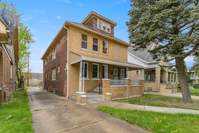 traditional style home featuring concrete driveway, a porch, brick siding, and fence