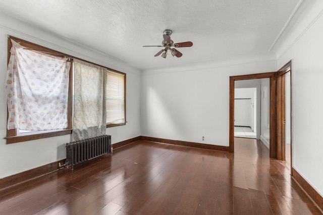 unfurnished room with ornamental molding, wood finished floors, ceiling fan, and radiator heating unit