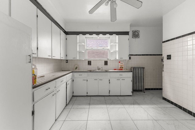 kitchen with radiator, white cabinets, tile walls, ceiling fan, and light countertops