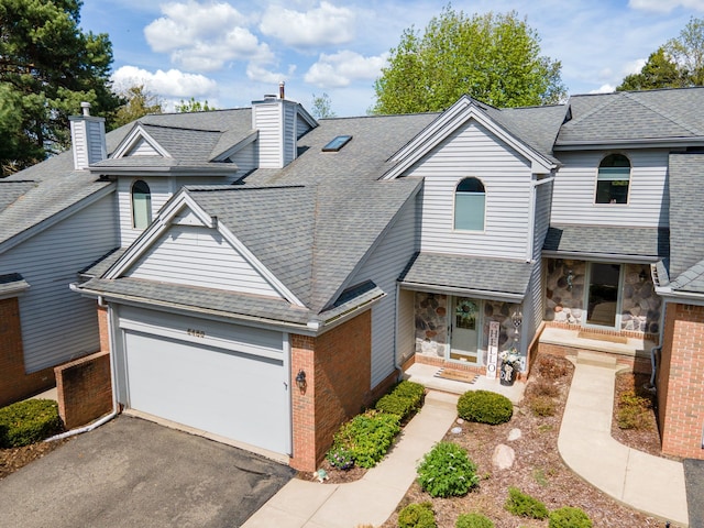 6480 Scenic Pines Ct, Clarkston, MI 48346 - view of front of house with a chimney, an attached garage, roof with shingles, driveway, and brick siding