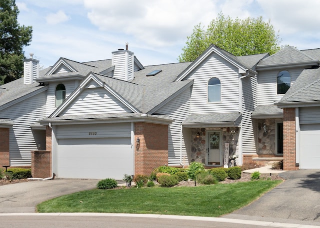 6480 Scenic Pines Ct, Clarkston, MI 48346 - view of front of house with asphalt driveway, an attached garage, a chimney, a shingled roof, and brick siding
