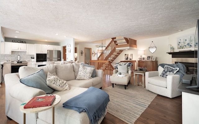 6480 Scenic Pines Ct, Clarkston, MI 48346 - living area featuring a textured ceiling, stairway, wood finished floors, a fireplace, and recessed lighting