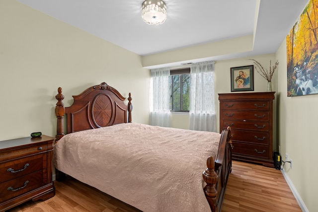 bedroom featuring light wood-style floors and baseboards