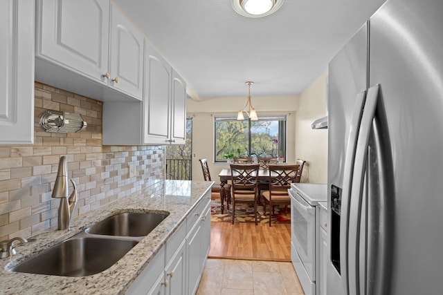 kitchen with stainless steel fridge, a sink, white cabinetry, backsplash, and white electric range