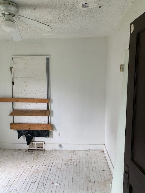 spare room with a ceiling fan, a textured ceiling, and hardwood / wood-style flooring