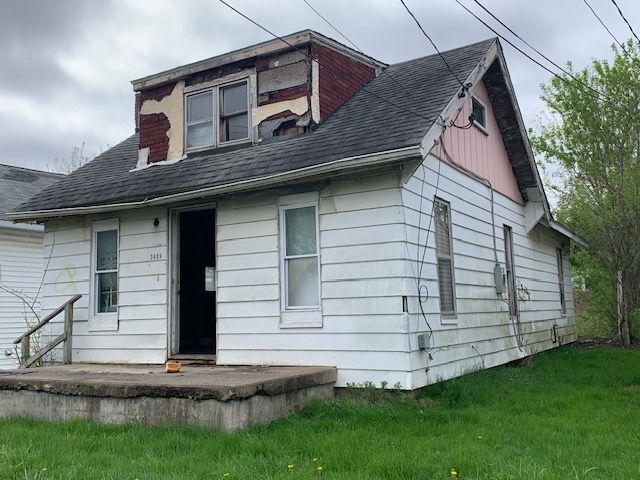 view of front of home featuring roof with shingles and a front yard
