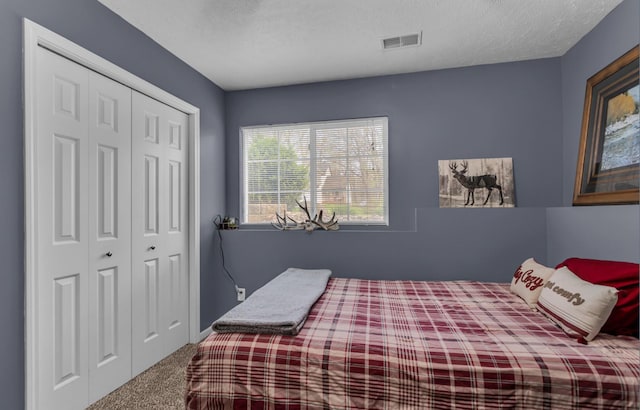 carpeted bedroom featuring a closet and visible vents