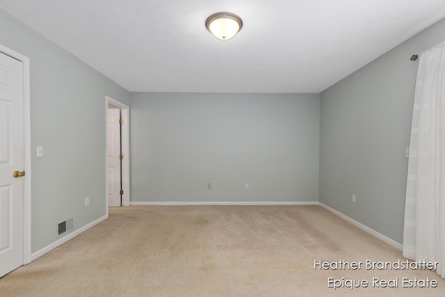 interior space featuring light colored carpet, visible vents, and baseboards
