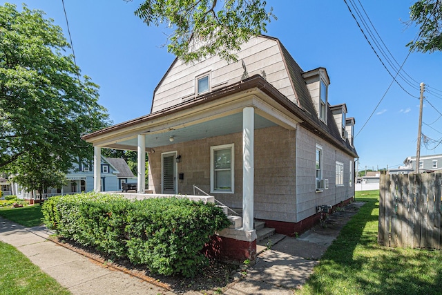 view of front facade with covered porch and a gambrel roof