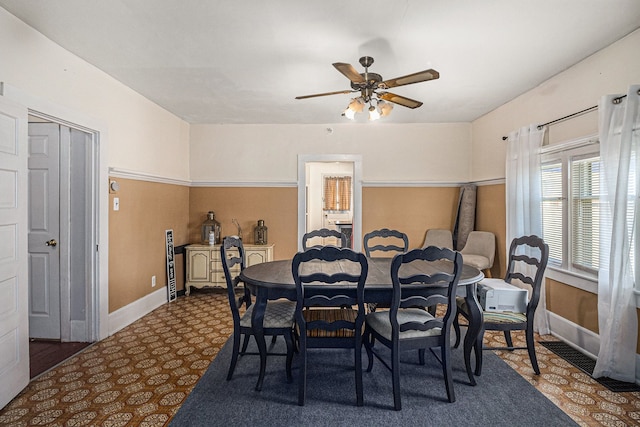 dining space featuring a ceiling fan and baseboards