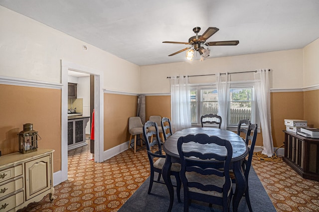 dining space featuring a ceiling fan and baseboards