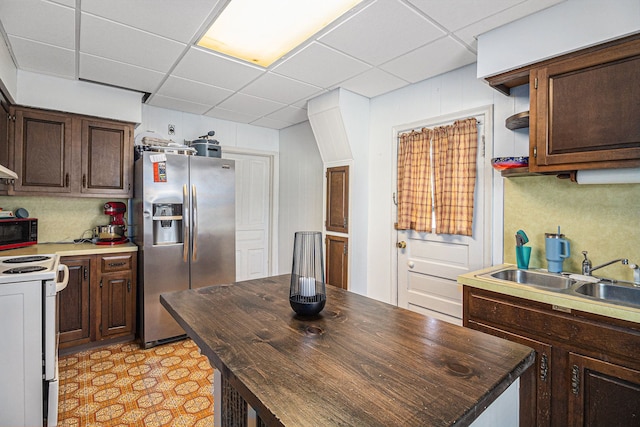 kitchen featuring stainless steel fridge, white electric range, a sink, black microwave, and a drop ceiling