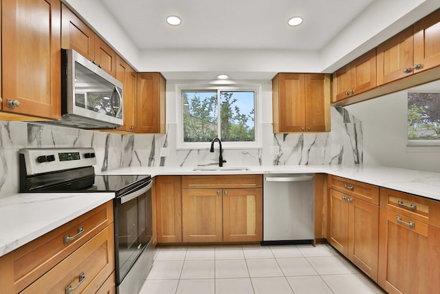 kitchen featuring stainless steel appliances, a sink, healthy amount of natural light, decorative backsplash, and recessed lighting