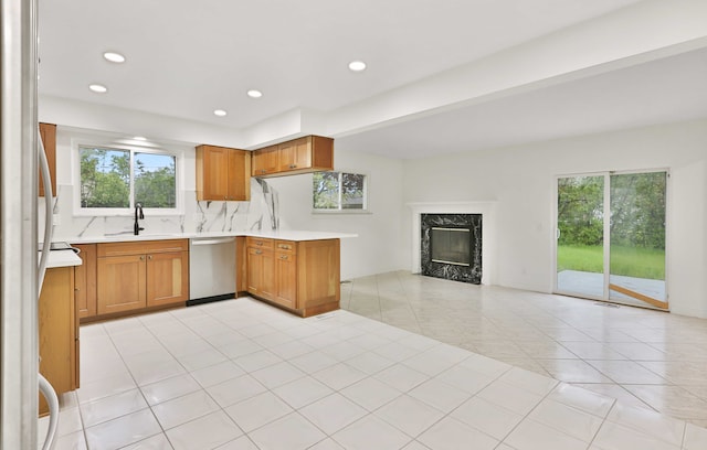 kitchen with dishwasher, a sink, light countertops, plenty of natural light, and recessed lighting