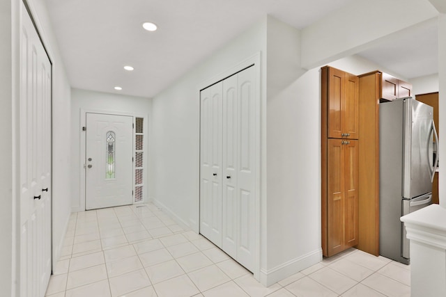 foyer entrance with recessed lighting, baseboards, and light tile patterned flooring