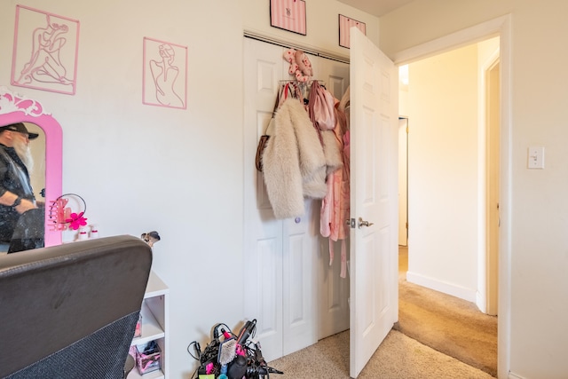 bedroom featuring light carpet, baseboards, and a closet