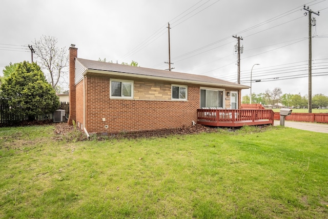 rear view of house with brick siding, a chimney, a wooden deck, and central air condition unit