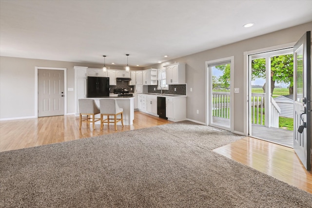 living room featuring baseboards, light wood-style flooring, and recessed lighting