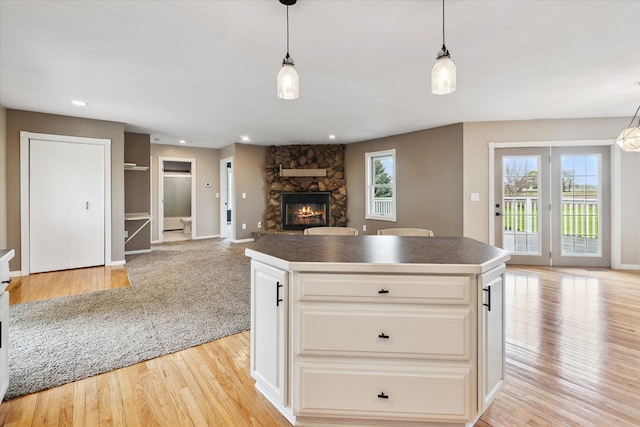 kitchen featuring dark countertops, a fireplace, light wood-type flooring, and plenty of natural light