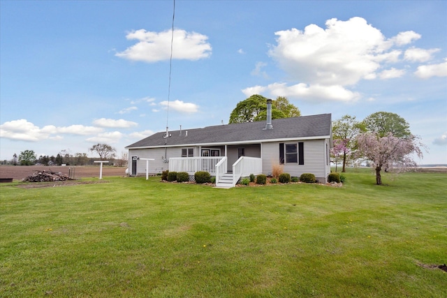 rear view of house featuring a yard