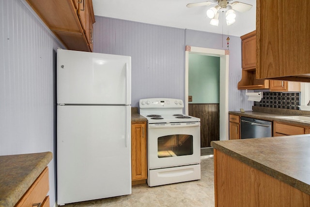 kitchen featuring brown cabinetry, white appliances, ceiling fan, decorative backsplash, and dark countertops