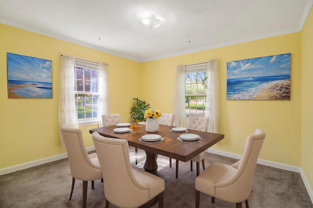 carpeted dining space with baseboards and crown molding