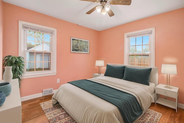 bedroom featuring baseboards, visible vents, and multiple windows
