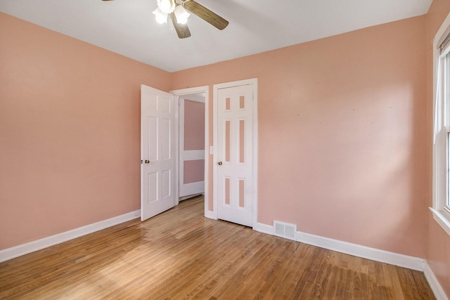 unfurnished bedroom with baseboards, ceiling fan, light wood finished floors, and visible vents