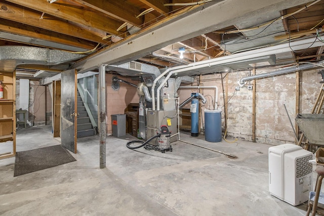 unfinished basement with stairs, heating unit, and a sink