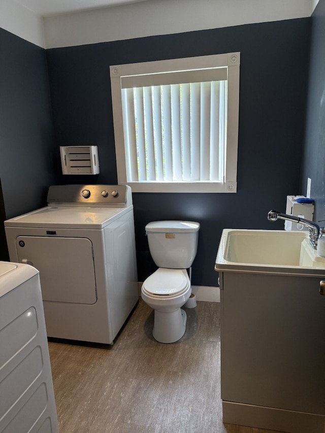 4212 4th St, Brown City, MI 48416 - bathroom with a sink, washer and clothes dryer, toilet, and wood finished floors