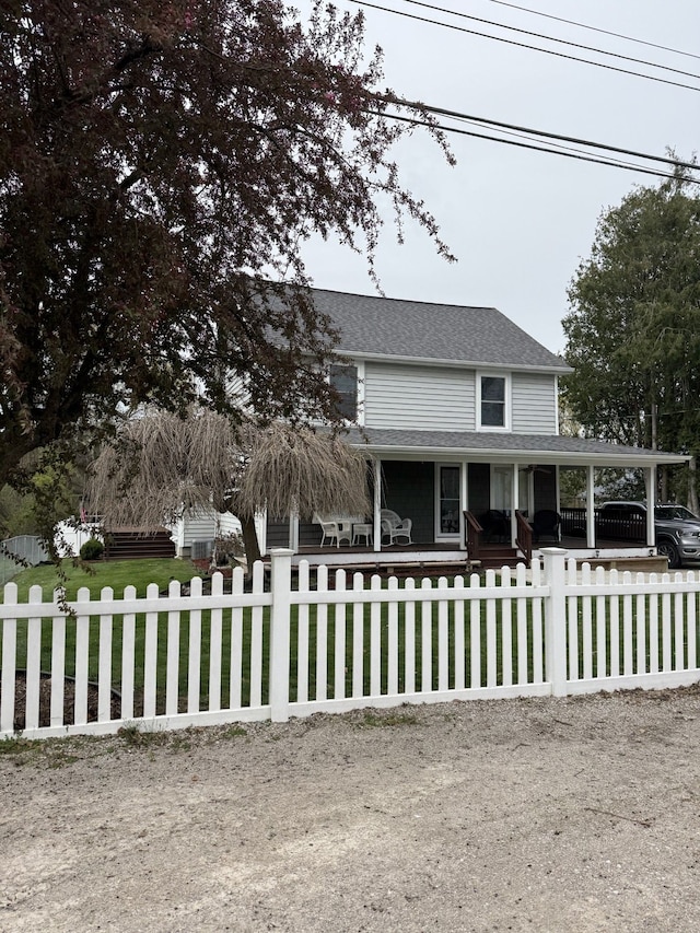 4212 4th St, Brown City, MI 48416 - country-style home with covered porch, roof with shingles, and a fenced front yard