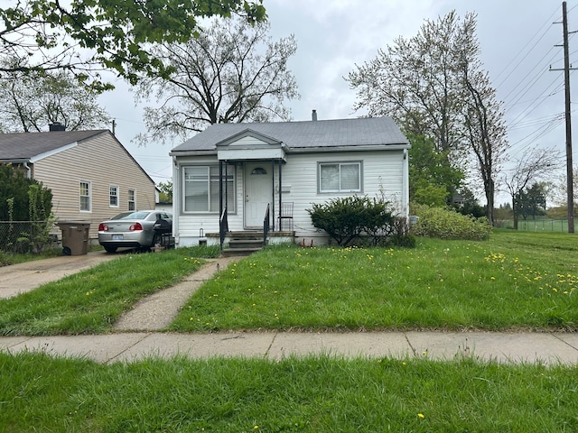 bungalow-style home with a front yard