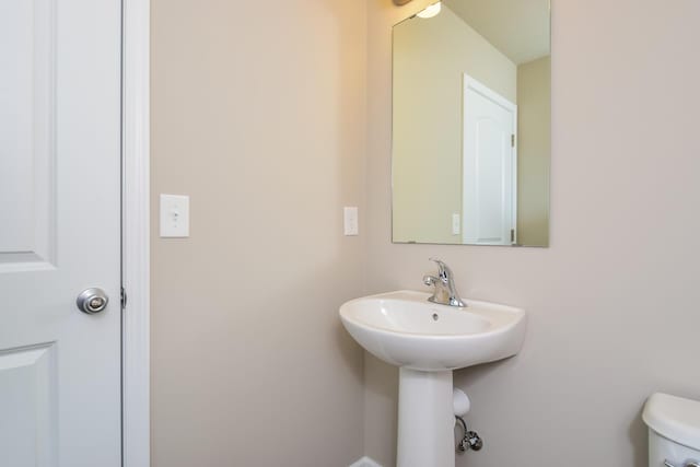half bath featuring a sink and toilet