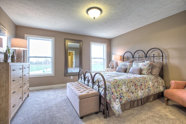 carpeted bedroom with a textured ceiling and baseboards