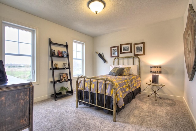 bedroom featuring a textured ceiling, carpet floors, and baseboards