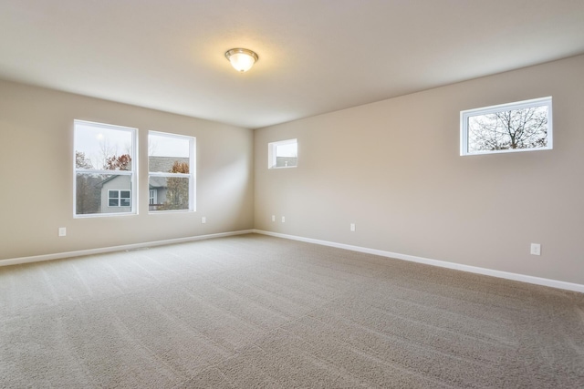 spare room featuring carpet flooring and baseboards