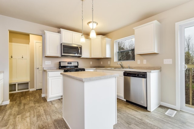 kitchen featuring light countertops, visible vents, a sink, light wood-style floors, and stainless steel appliances