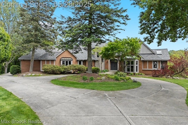 4395 Hickory Ct, Orchard Lake, MI 48323 - view of front of property with brick siding, curved driveway, and board and batten siding