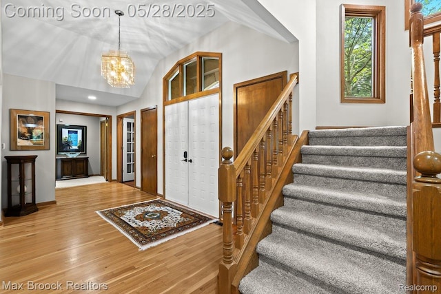 4395 Hickory Ct, Orchard Lake, MI 48323 - entrance foyer featuring stairway, wood finished floors, a chandelier, baseboards, and vaulted ceiling