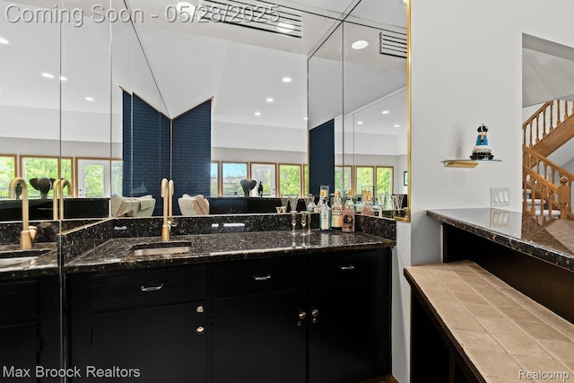 4395 Hickory Ct, Orchard Lake, MI 48323 - kitchen with dark cabinetry, open floor plan, a sink, recessed lighting, and dark stone countertops
