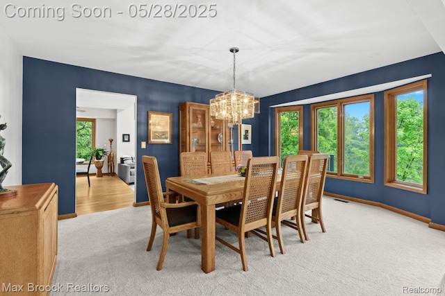 4395 Hickory Ct, Orchard Lake, MI 48323 - dining area with light colored carpet, a chandelier, and baseboards