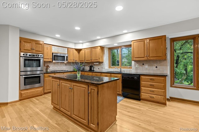 4395 Hickory Ct, Orchard Lake, MI 48323 - kitchen featuring appliances with stainless steel finishes, a kitchen island, light wood-type flooring, tasteful backsplash, and baseboards