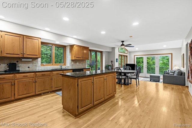 4395 Hickory Ct, Orchard Lake, MI 48323 - kitchen with a kitchen island, a sink, a ceiling fan, backsplash, and light wood-style flooring
