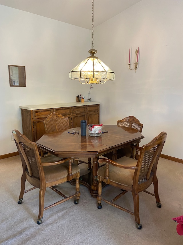 dining area with light carpet and baseboards