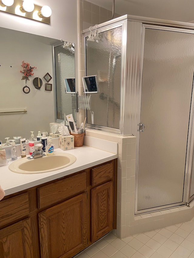 full bath with a stall shower, tile patterned flooring, and vanity