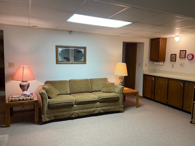 living area with a paneled ceiling and light carpet