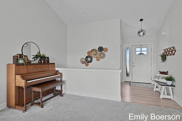 foyer with baseboards, high vaulted ceiling, and carpet floors