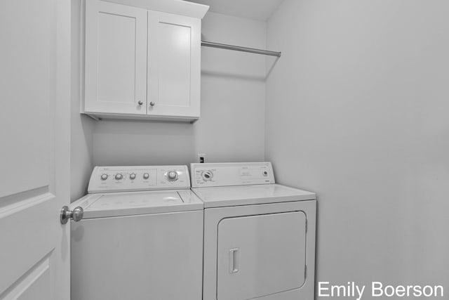 clothes washing area with washing machine and clothes dryer and cabinet space