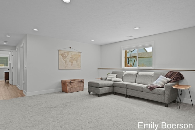 carpeted living room featuring a healthy amount of sunlight, baseboards, visible vents, and recessed lighting