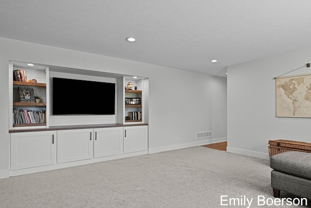 carpeted living area featuring visible vents, baseboards, and recessed lighting